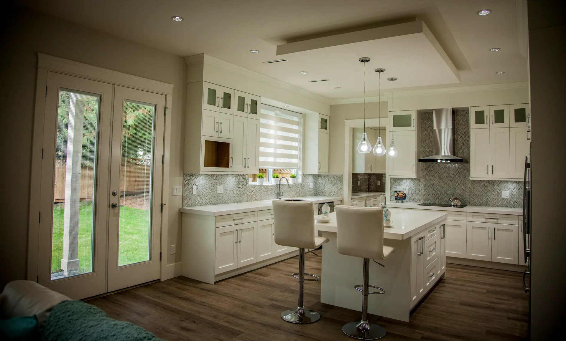 Kitchen from the great room with island seating and french doors to the yard