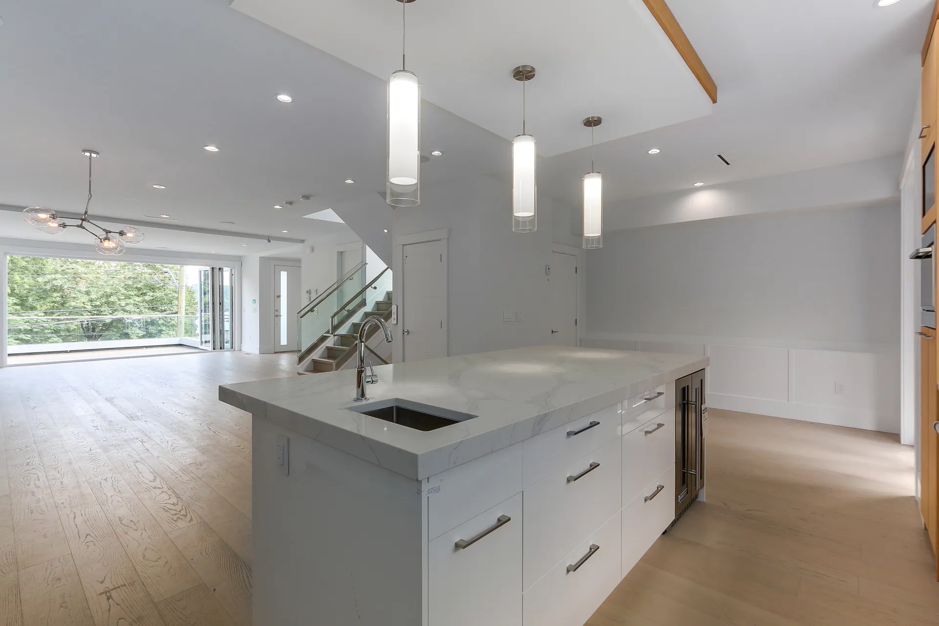 Kitchen island with pendant lighting open to the living area and view deck