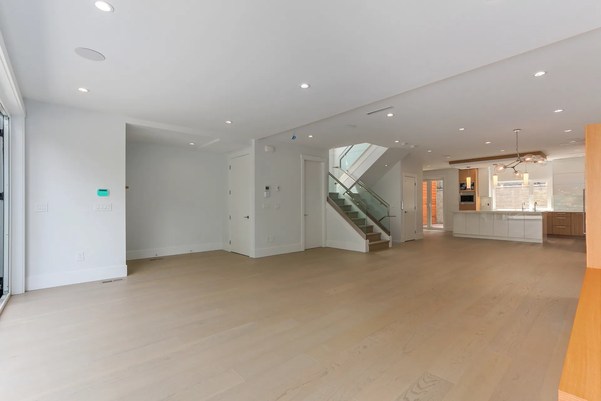 Open main floor with staircase and kitchen beyond