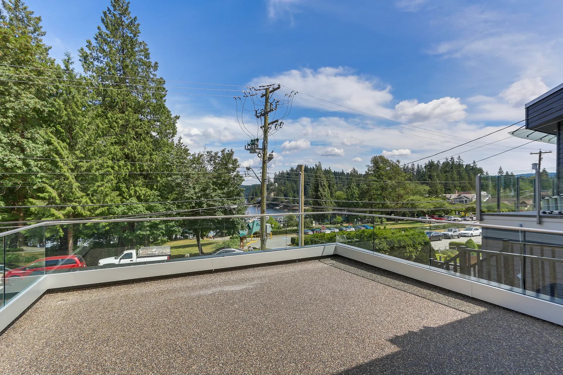 Upper deck with glass railings above the tree lined street