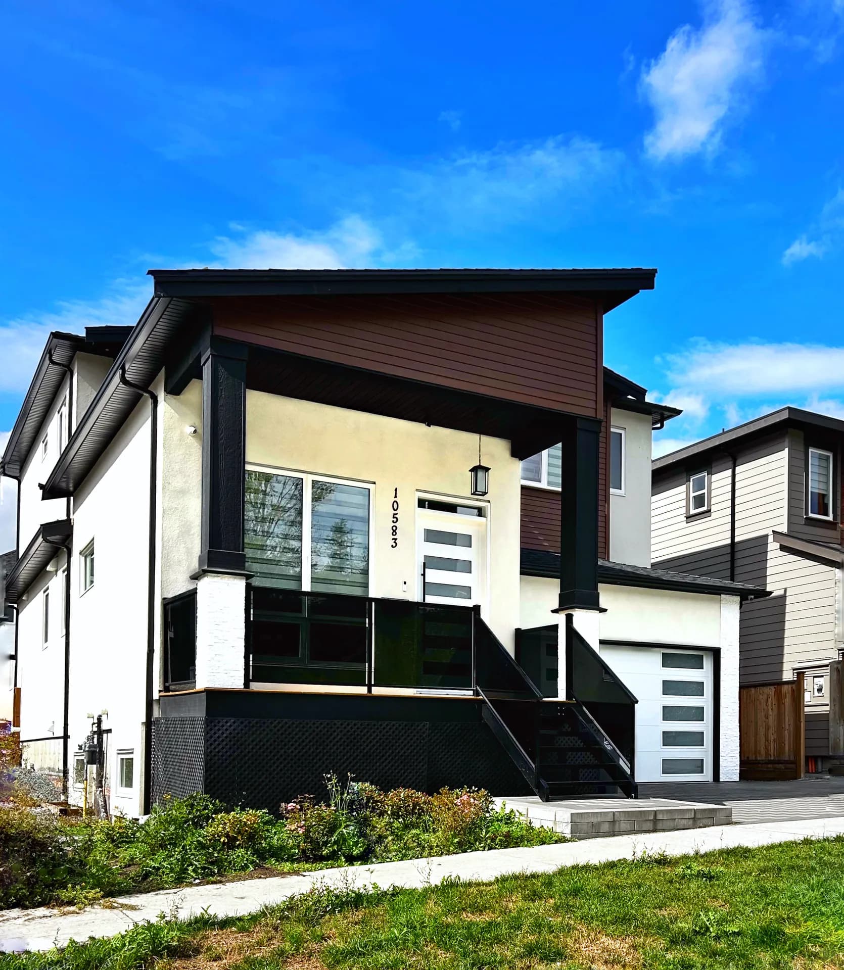 Angled front exterior with smoked glass porch railing and elevated entry stairs