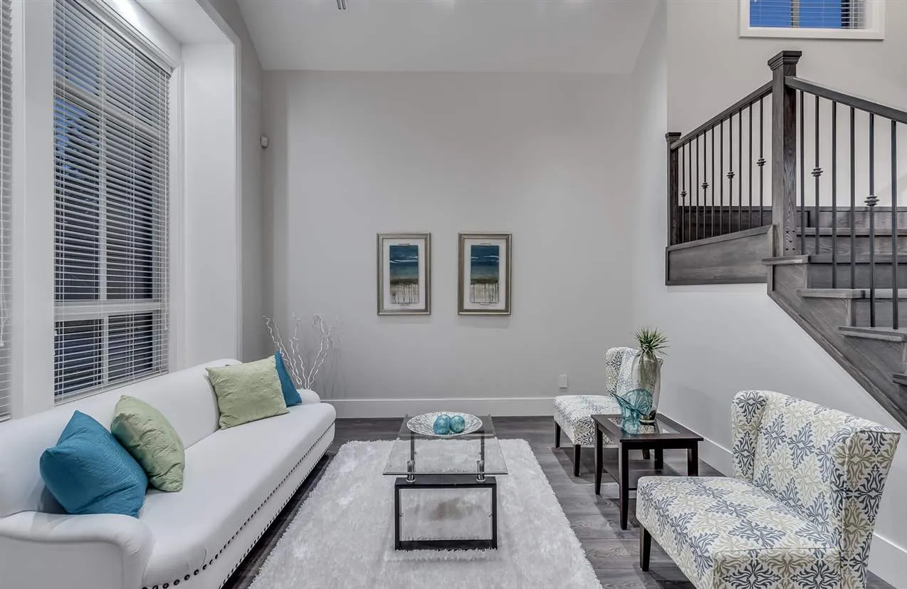 Formal sitting room with tall window and wood staircase railing