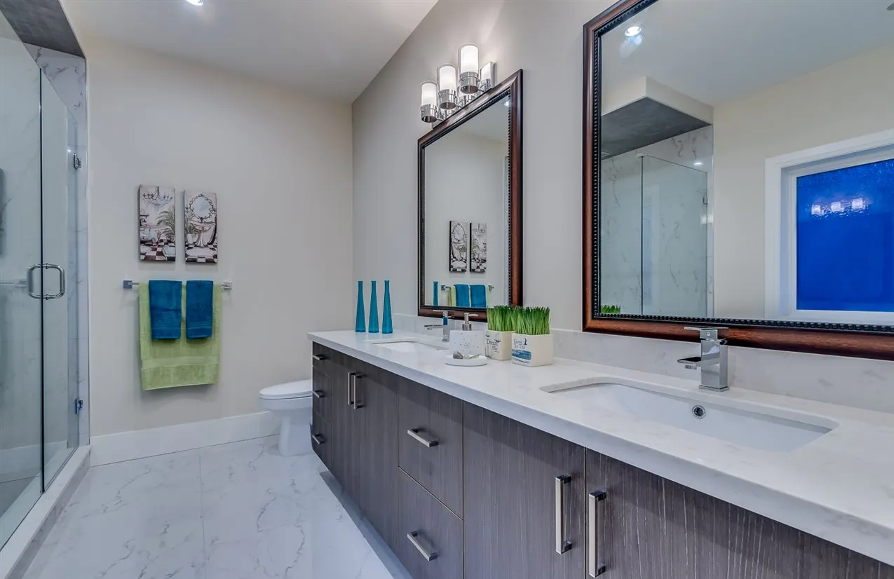 Double vanity bathroom with quartz counters and glass shower